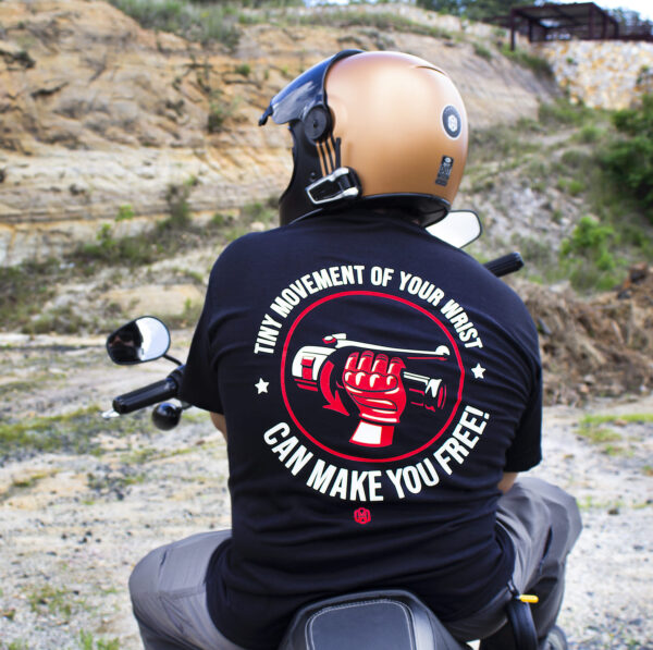 Playera motociclista Lhopital negra Tiny Movement con una mano acelerando a fondo una motocicleta en colores rojo y blanco